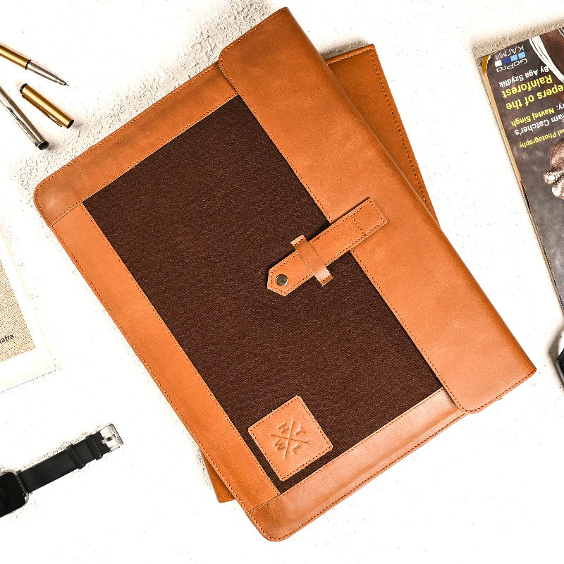Brown leather-bound notebook with a strap on a white surface