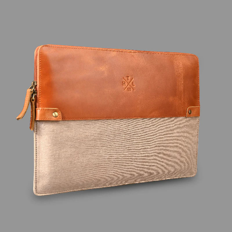 Brown leather and beige fabric pouch on a gray background