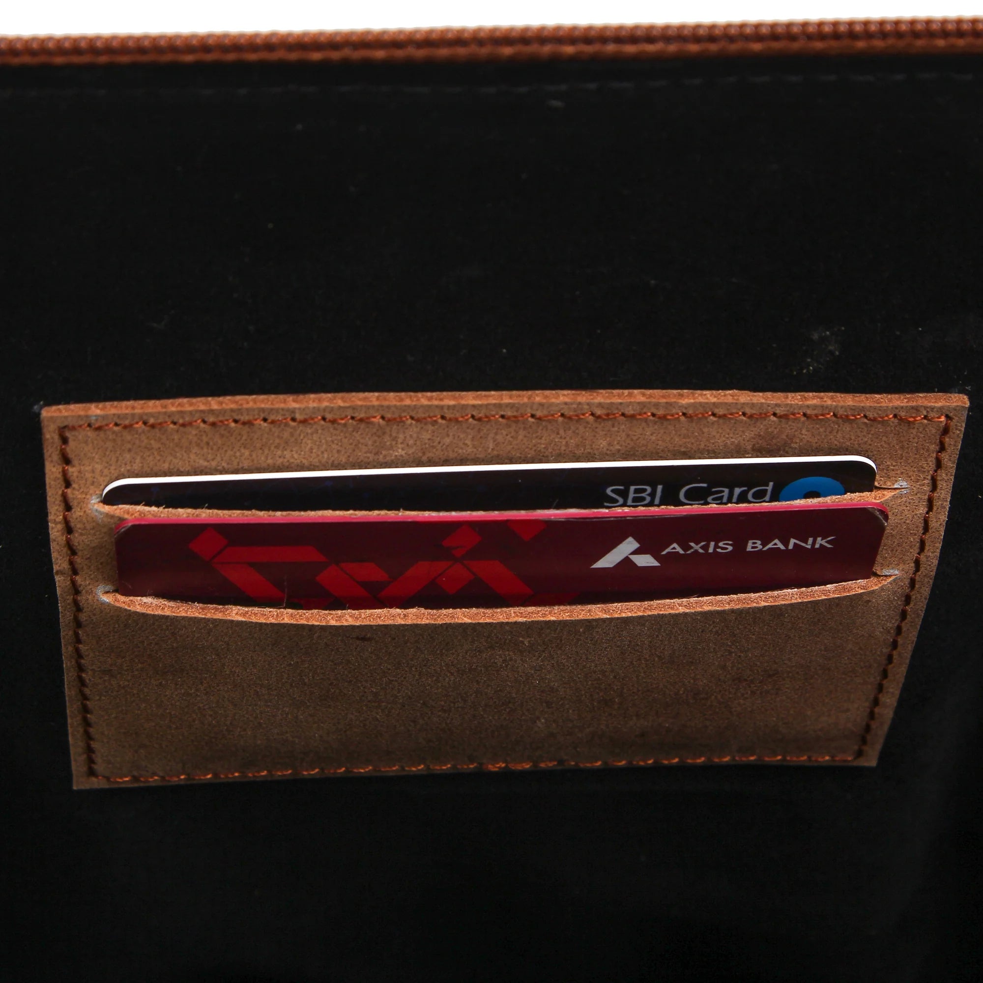 Brown cardholder with Axis Bank and SBI cards on a black background