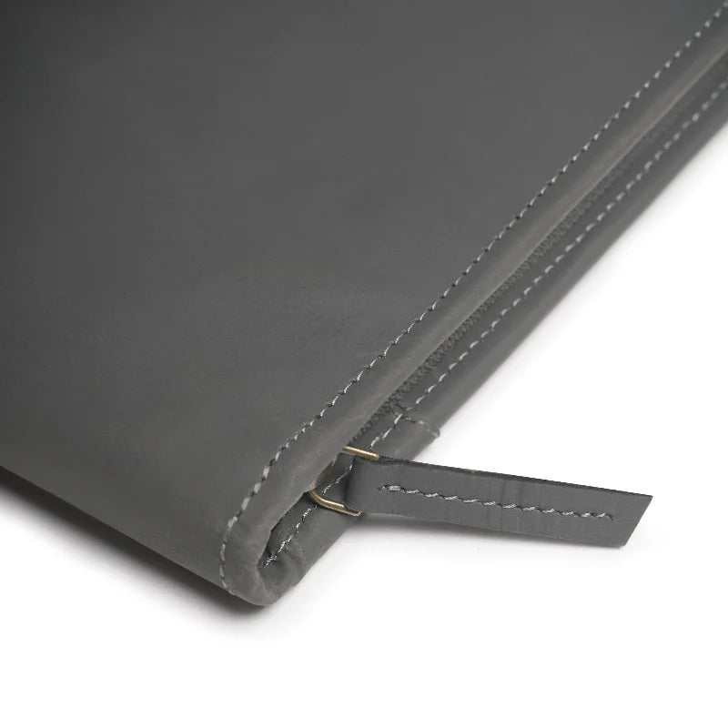 Close-up of a gray leather product with stitching detail on a white background