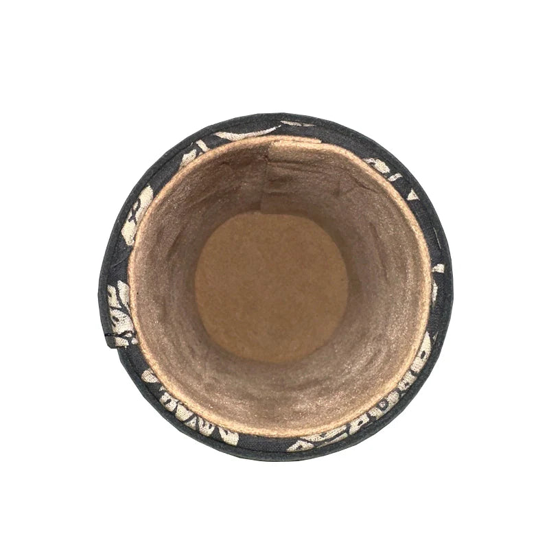 Cylindrical wooden product with black rim and decorative patterns on a white background