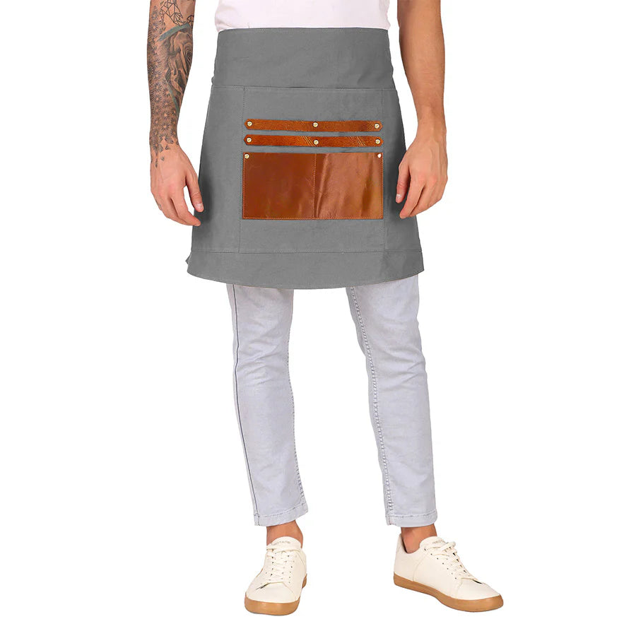 Person wearing a gray apron with brown leather pockets on a white background