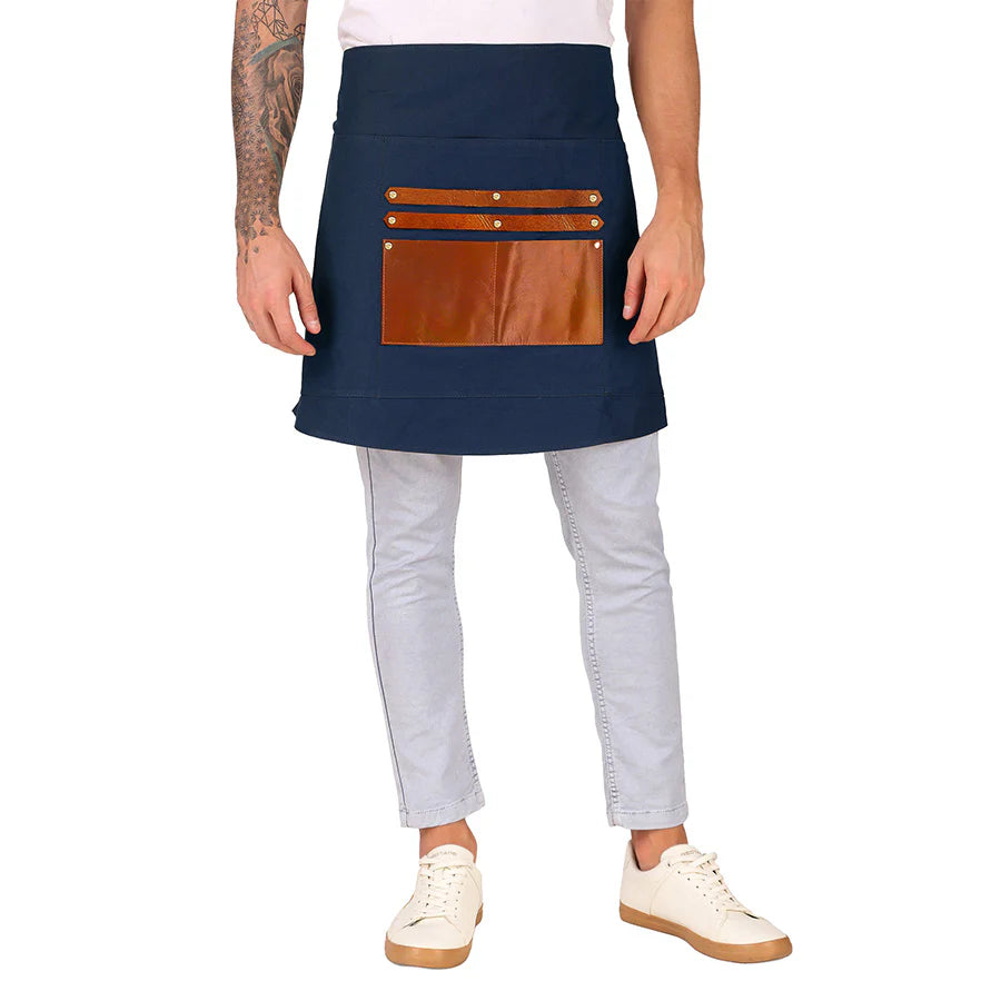 Person wearing a navy apron with brown leather pockets on a white background