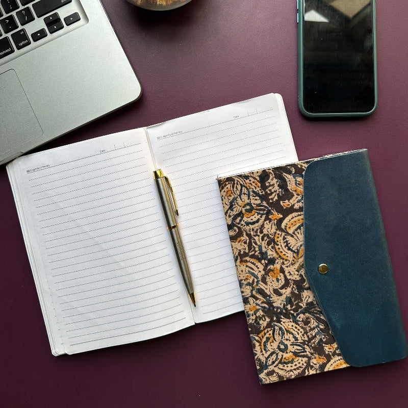 Open notebook with pen, wallet, and phone on a purple surface