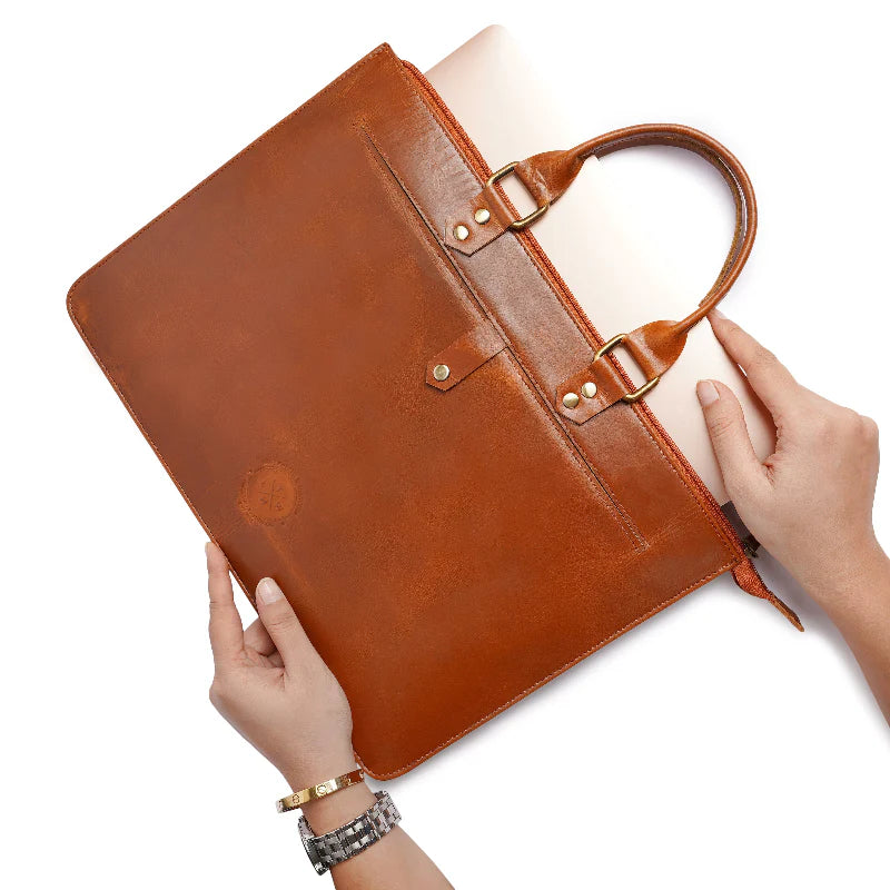 Brown leather briefcase held by a person on a white background