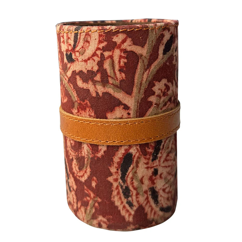 Cylindrical fabric case with floral pattern and brown band on a white background
