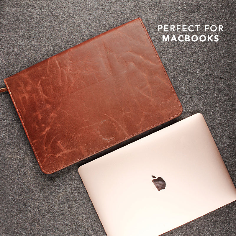 Brown leather case on a MacBook on a gray surface with &