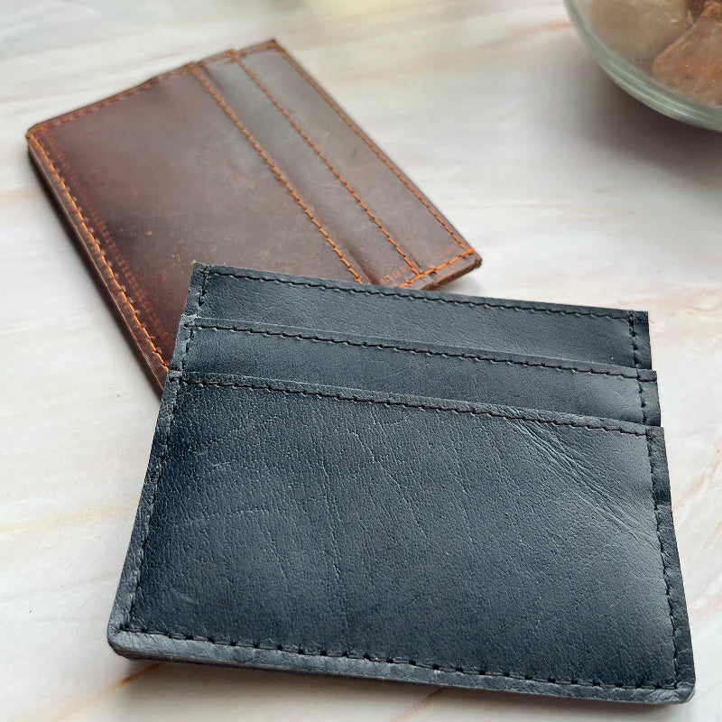 Black leather wallet on a light wooden surface
