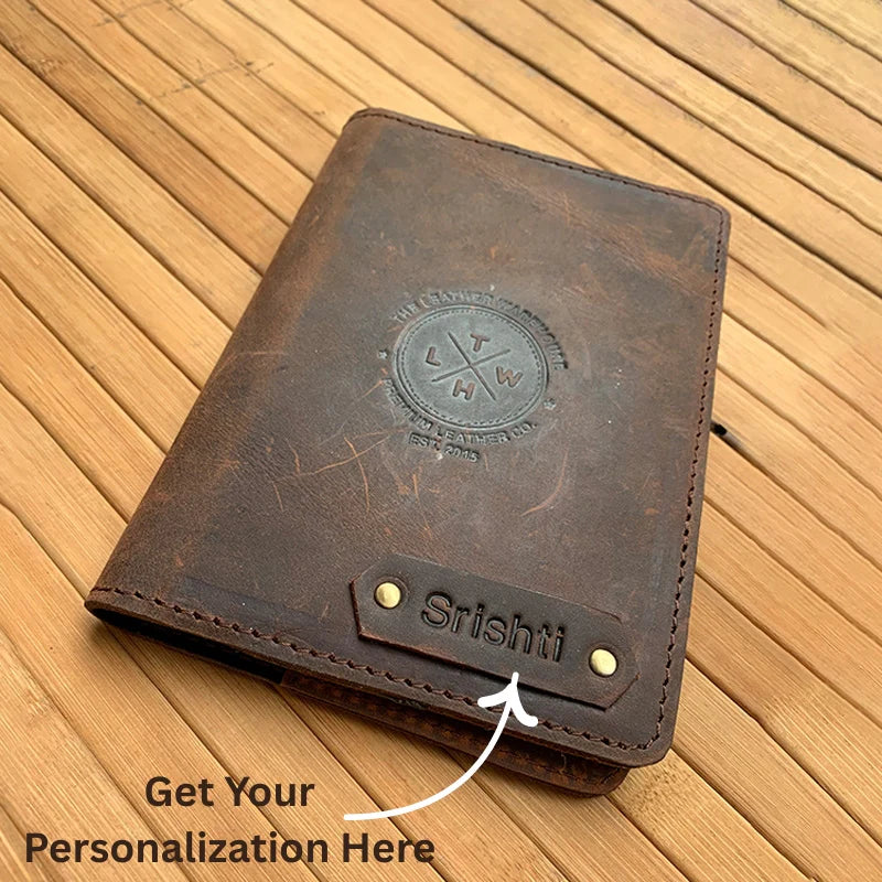 Brown leather wallet with personalized name on a wooden surface