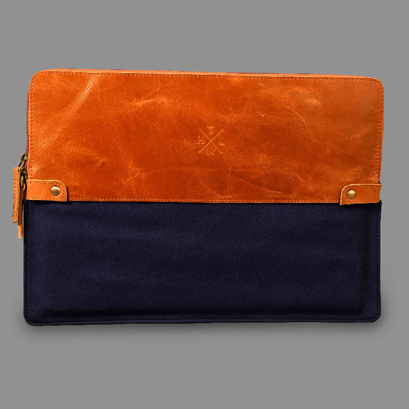 Two-tone leather clutch with brown top half and navy bottom half on a gray background
