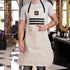 Person wearing a beige apron with a logo in a barbershop setting
