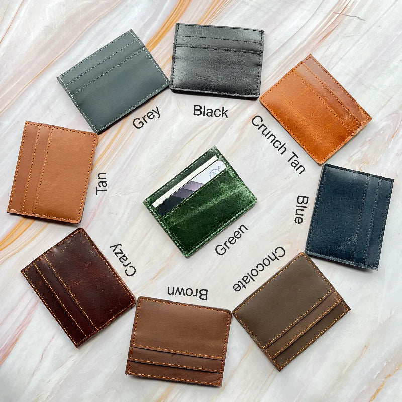 Collection of leather card holders in various colors on a marble surface