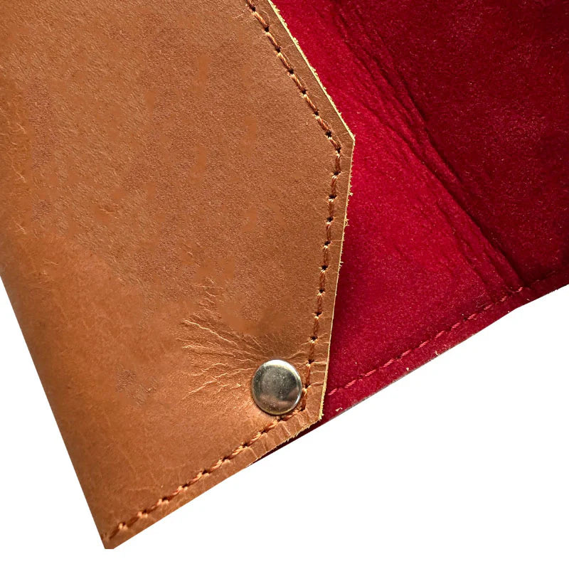 Close-up of a brown leather corner with a red fabric background