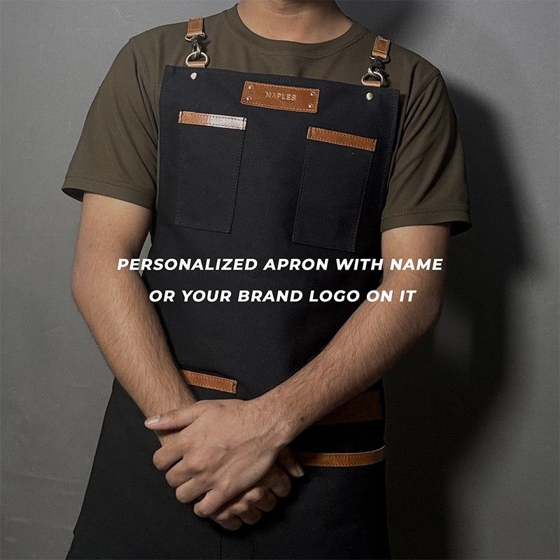 Person wearing a black apron with brown accents on a gray background