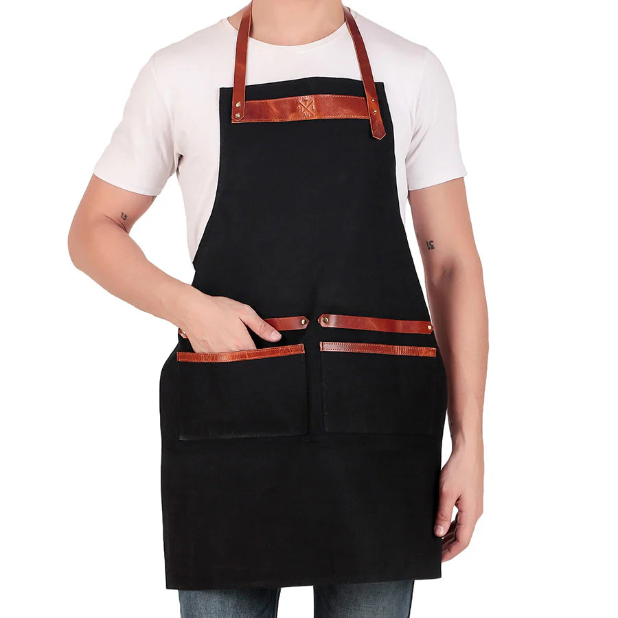 Person wearing a black apron with brown leather straps on a white background