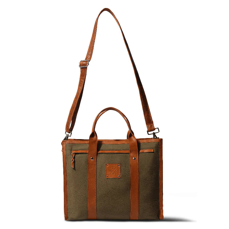 Brown leather and canvas bag with a strap on a white background