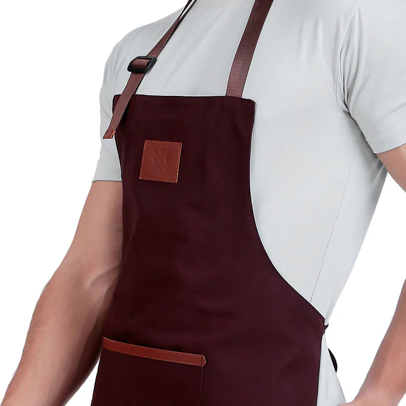 Brown apron with leather straps worn by a person on a white background