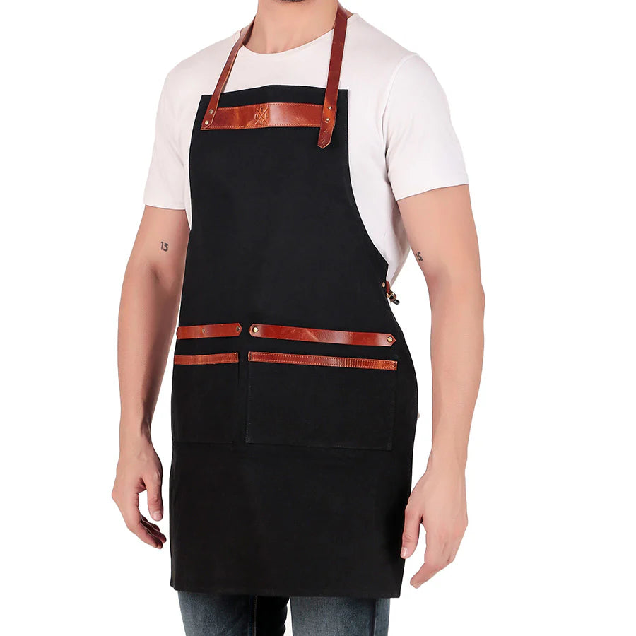 Person wearing a black apron with brown leather straps on a white background