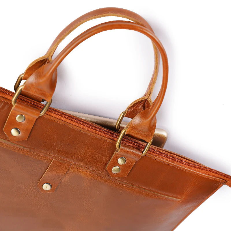 Brown leather bag with gold hardware on a white background