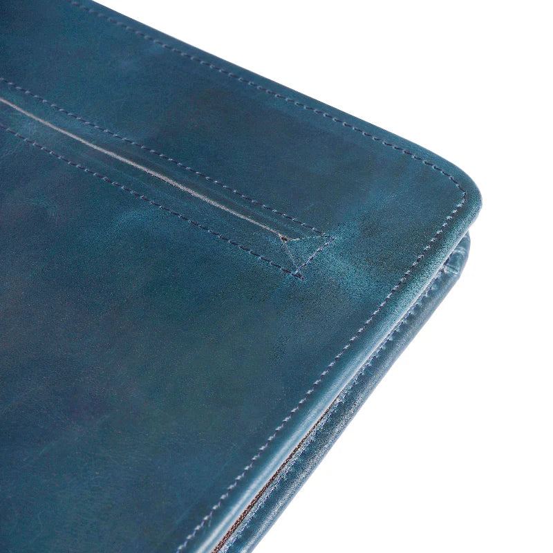 Close-up of a blue leather wallet with stitching detail on a white background