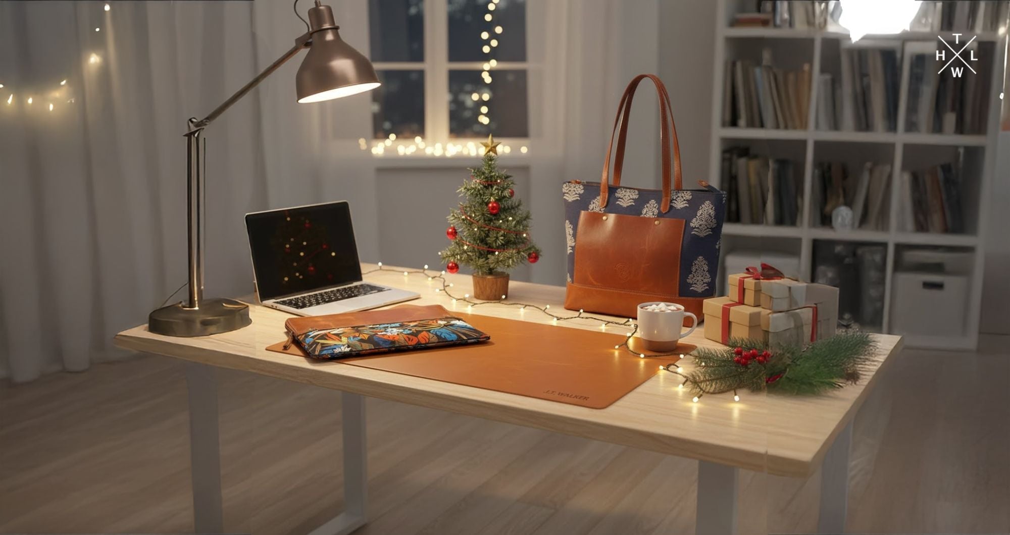 Aesthetic Christmas workspace setup featuring a leather desk mat, floral Kalamkari laptop sleeve, leather tote bag, mini Christmas tree, and gift boxes arranged beautifully as the Best Christmas Gifts.