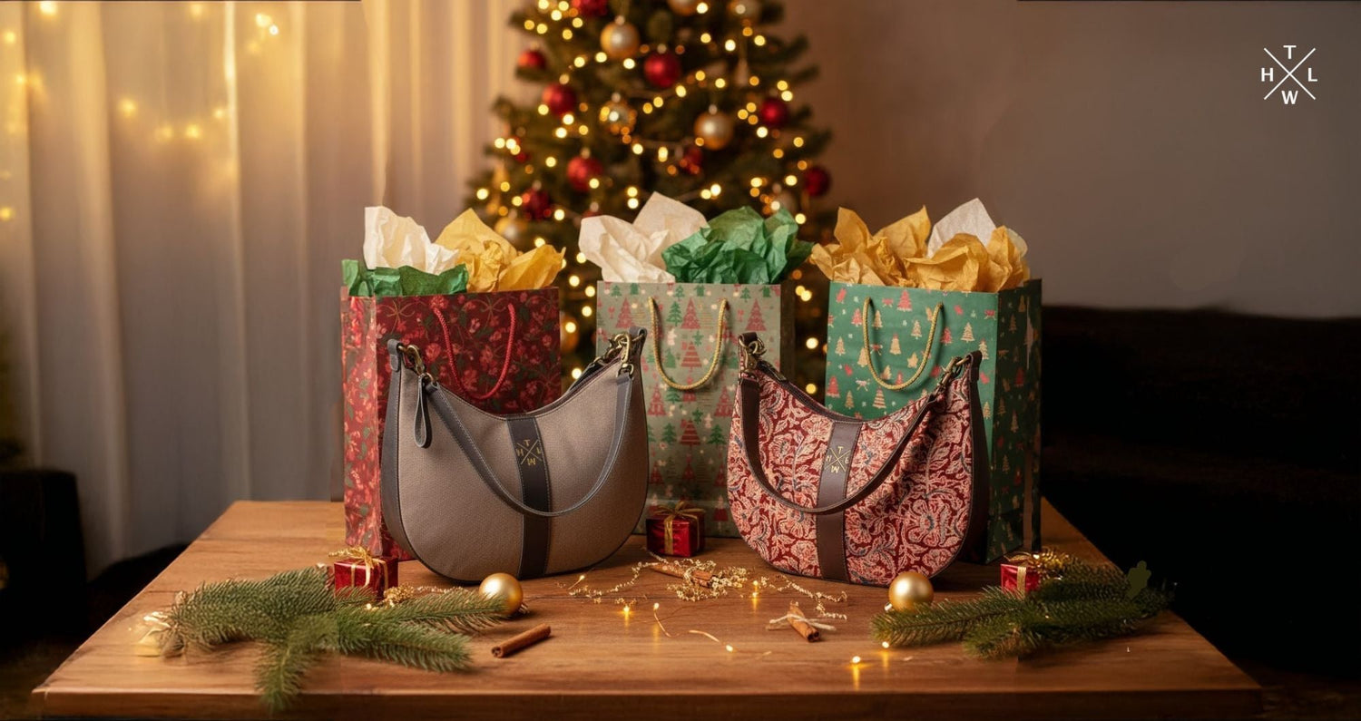 Christmas scene displaying festive gift bags and two floral shoulder bags on a wooden table with warm lights and a decorated tree in the background showing gift ideas at Christmas for easy holiday gifting.