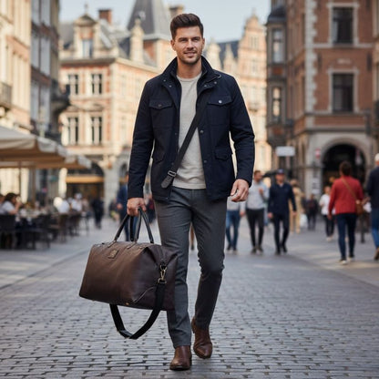 Man walking down a city street holding a brown leather bag