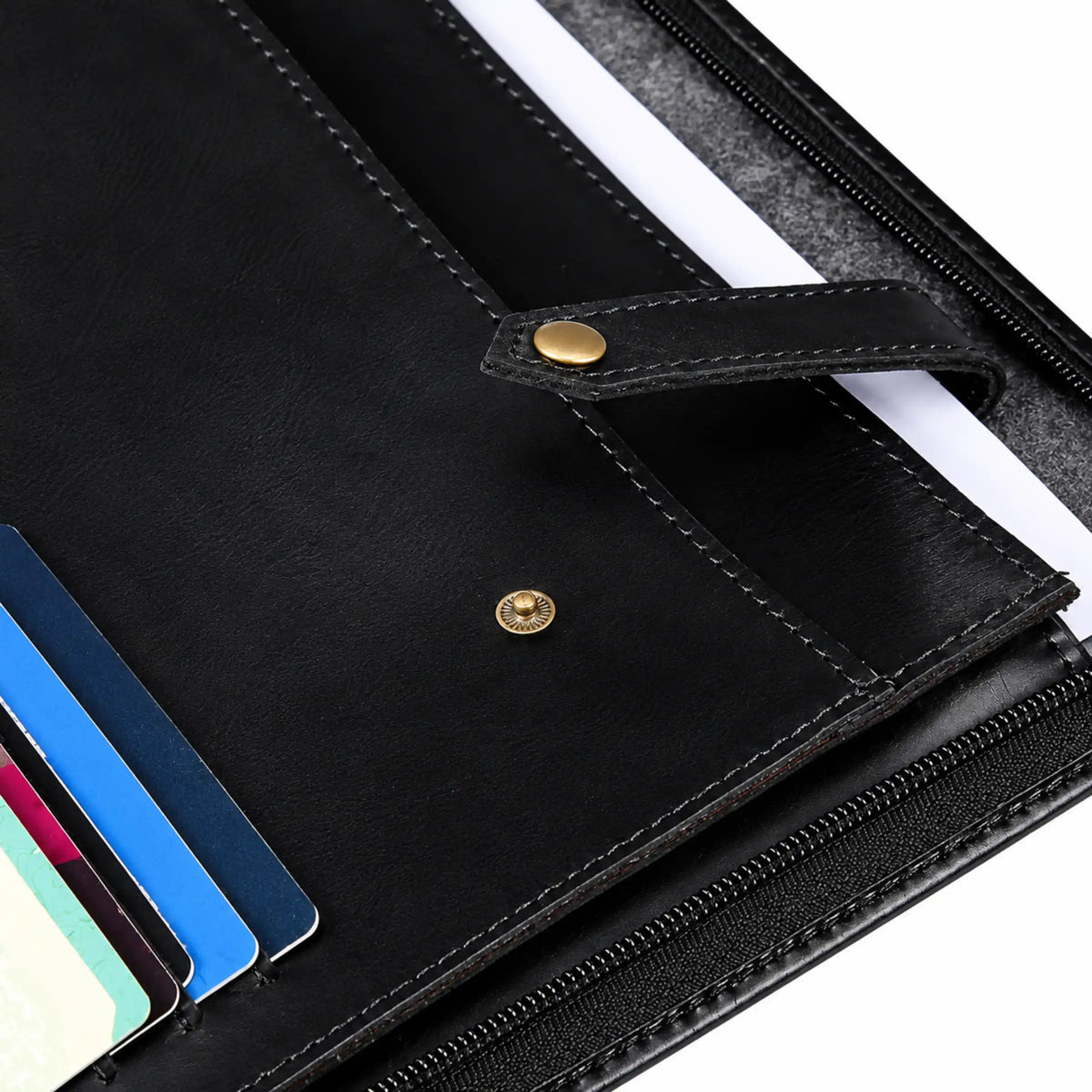 Close-up of a black leather wallet or planner shown open, with card slots, a zipper, and gold-tone snap details on a white background.