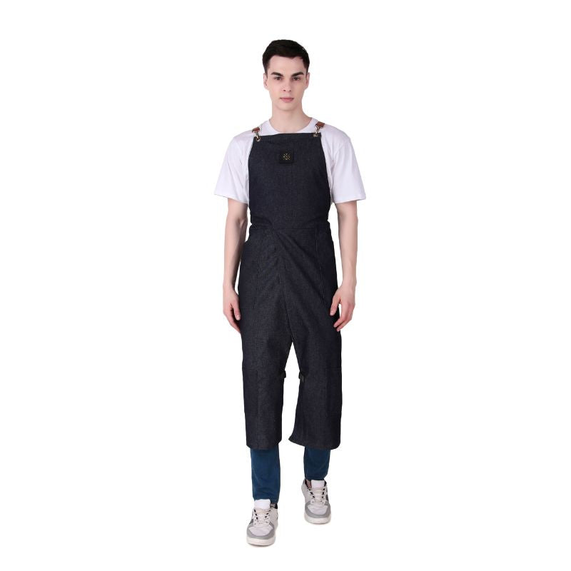 Person wearing dark denim overalls on a white background