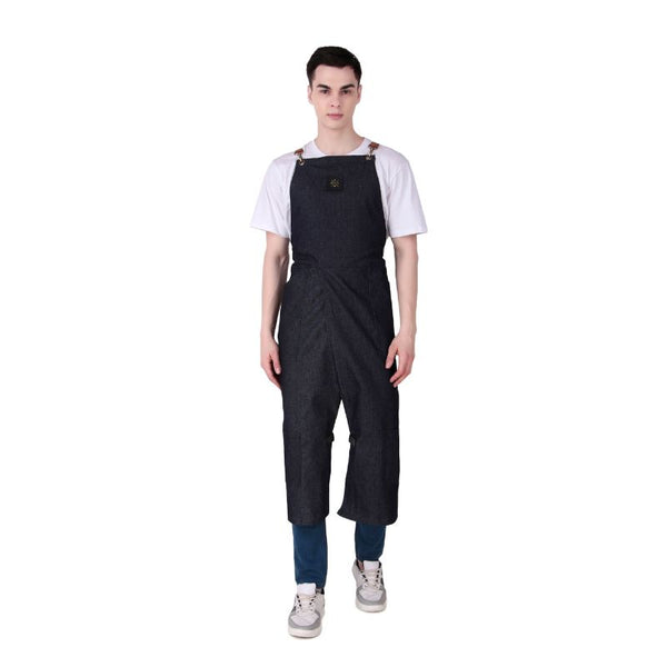 Person wearing dark denim overalls on a white background