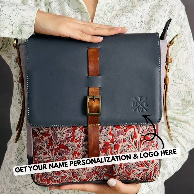 Handbag with floral patterned interior and dark blue exterior held by a person.
