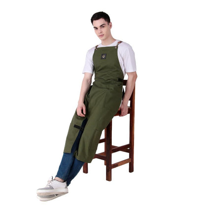 Person wearing a green apron sitting on a wooden stool against a white background