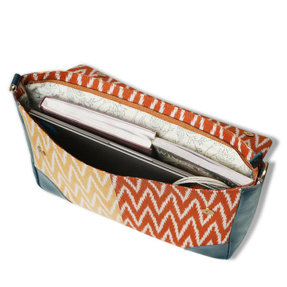 Clutch bag with orange and white zigzag pattern on a white background