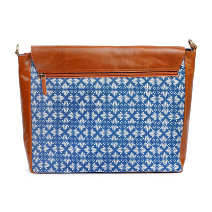 Handbag with blue floral pattern and brown leather top section on a white background