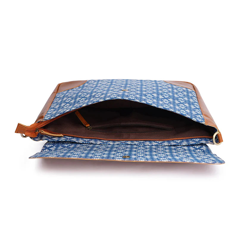 Blue patterned bag with brown leather accents on a white background