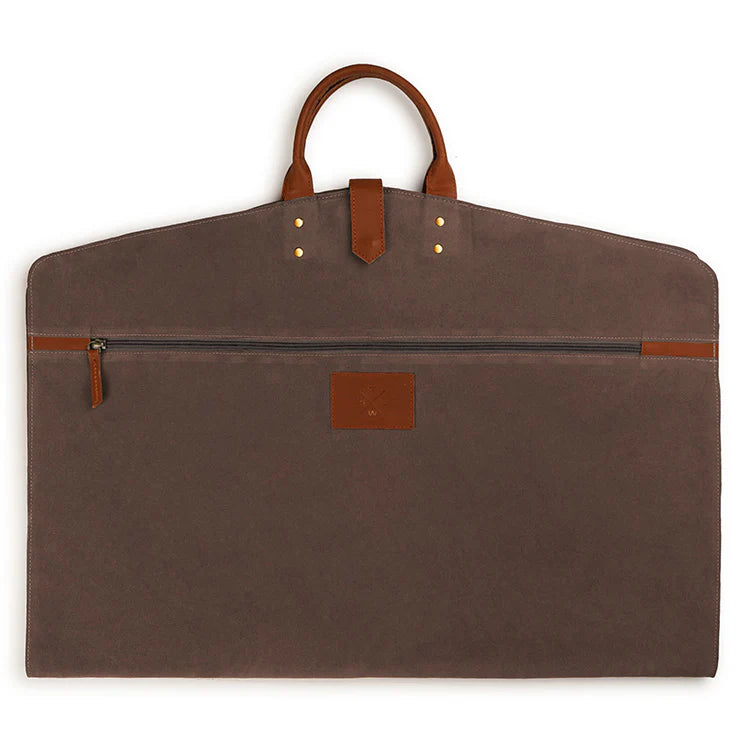 Brown garment bag with leather handles and trim on a white background
