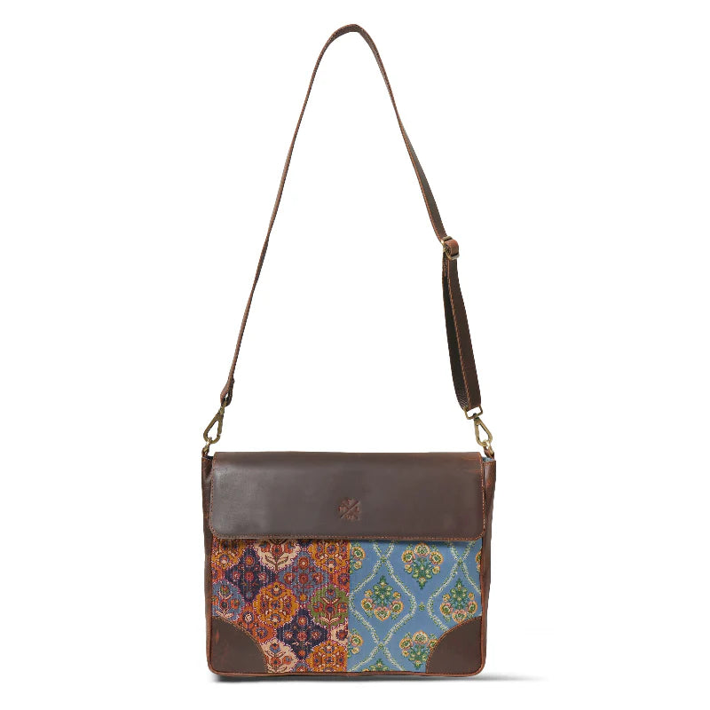Brown leather crossbody bag with patterned flap on a white background