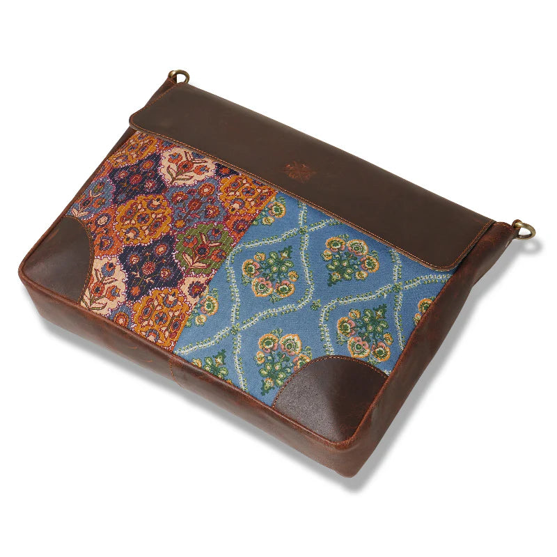 Multicolored patterned pouch with brown leather accents on a white background