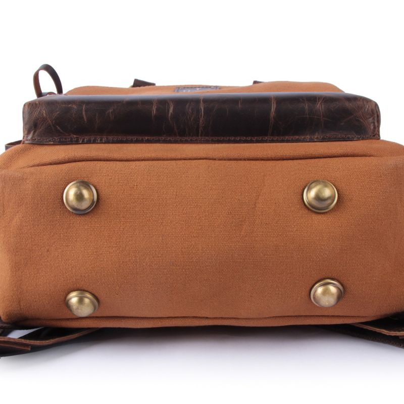 Brown leather backpack with gold studs on a white background