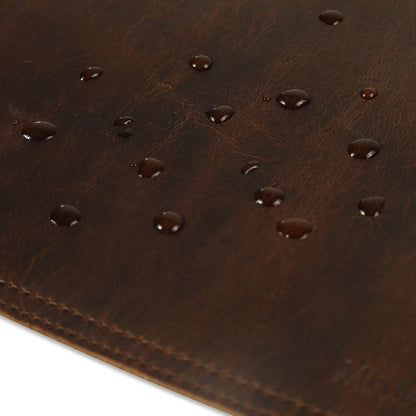 Close-up of a brown leather desk matwith water droplets.