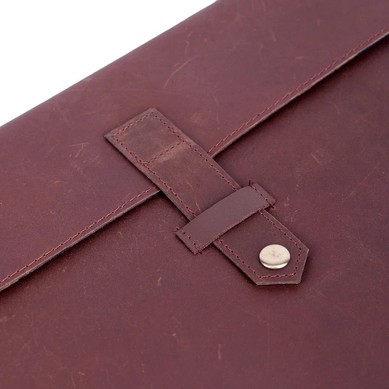 Close-up of a brown leather bag with a buckle detail on a white background