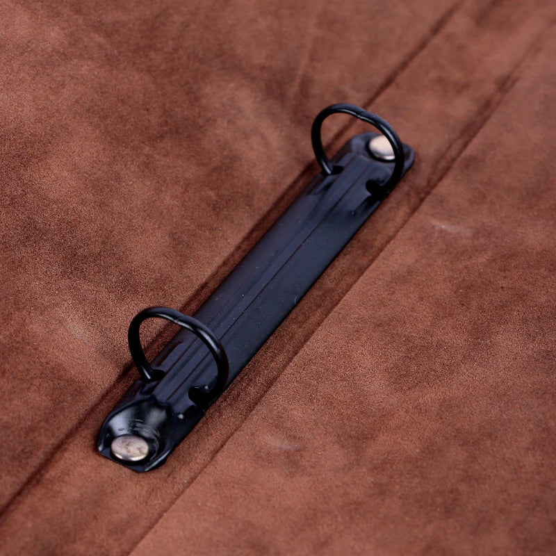 Black metal strap with two hooks on a brown leather background