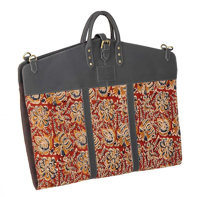 garment bag with floral pattern and dark leather accents on a white background