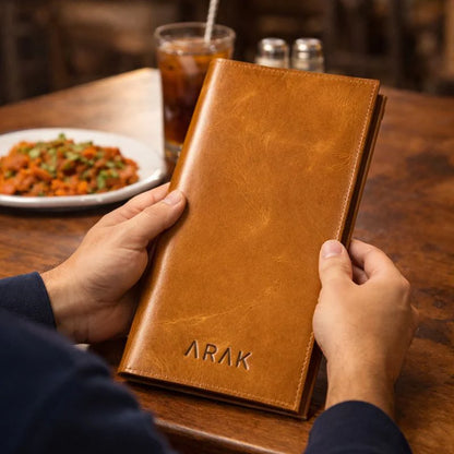 Person holding a brown leather menu with &