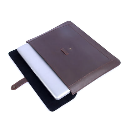 Brown leather laptop sleeve with a white laptop inside on a white background