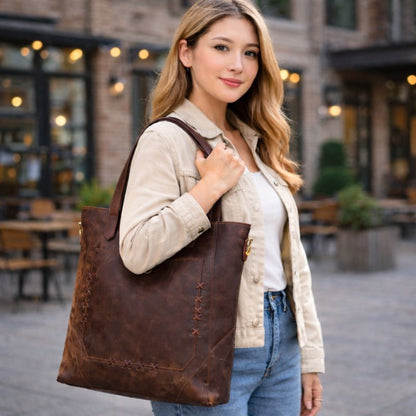 Woman holding a brown leather tote bag in an outdoor setting