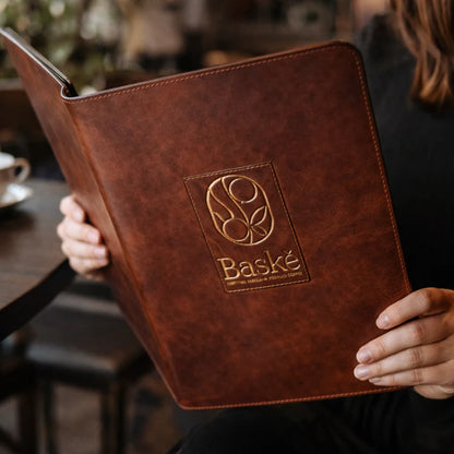 Person holding a brown menu with &