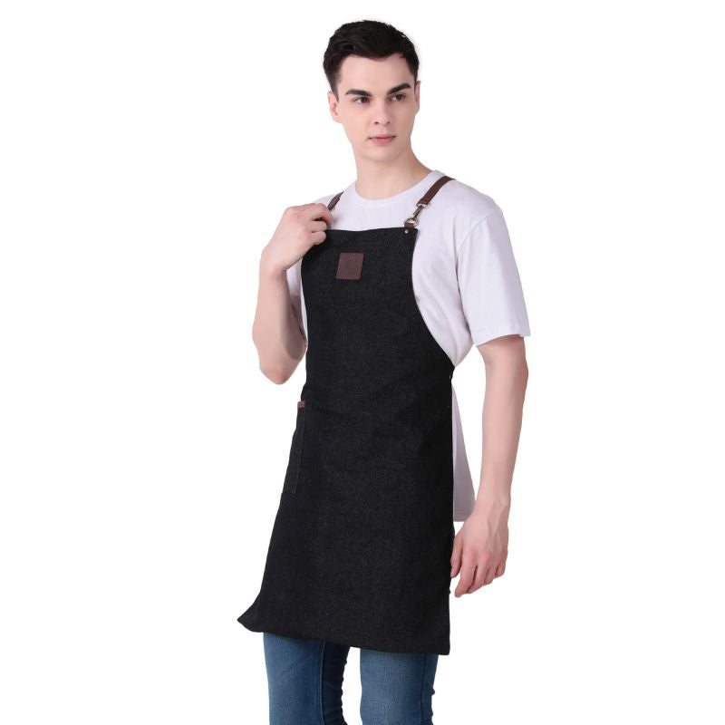 Person wearing a black apron with a brown leather patch on a white background