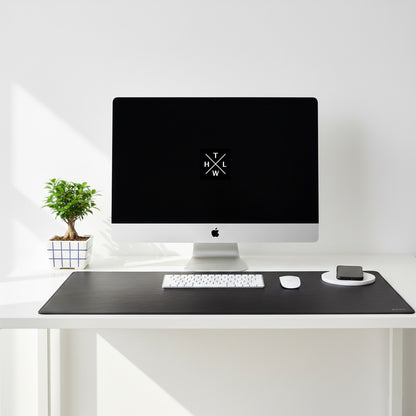Modern desk setup with a computer monitor, keyboard, and mouse on a white surface.