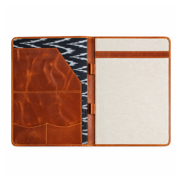 Open brown leather and canvas folder featuring document pockets, pen holders, and a black and white patterned interior